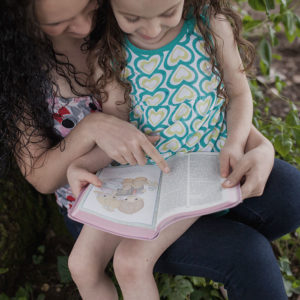Mother reading daughter Bible