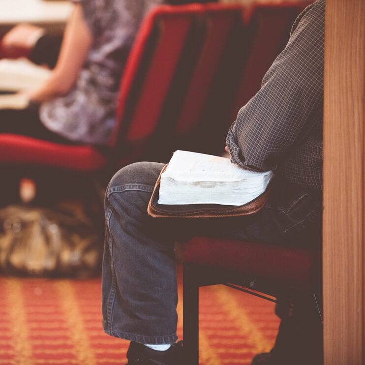 Man sitting in church with his Bible Open